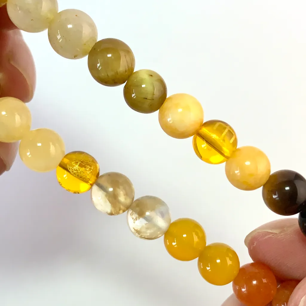Detail of the Earth Element Bracelet: faceted yellow tower crystal, gold tiger eye band, and golden rutilated quartz catching the light