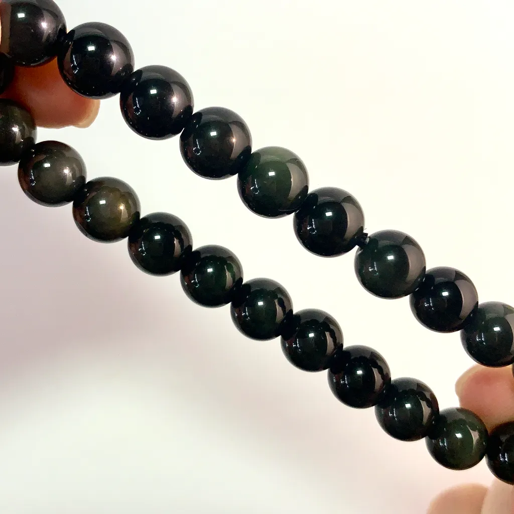 Close-up of Silver Obsidian Bracelet beads showing natural silver and golden sheen on black obsidian